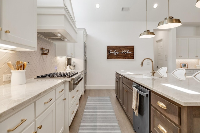 kitchen featuring decorative backsplash, appliances with stainless steel finishes, white cabinets, a sink, and visible vents