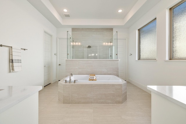 bathroom featuring a garden tub, a tile shower, visible vents, and vanity