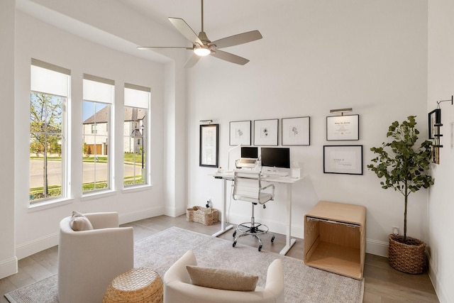office space featuring a ceiling fan, wood finished floors, and baseboards