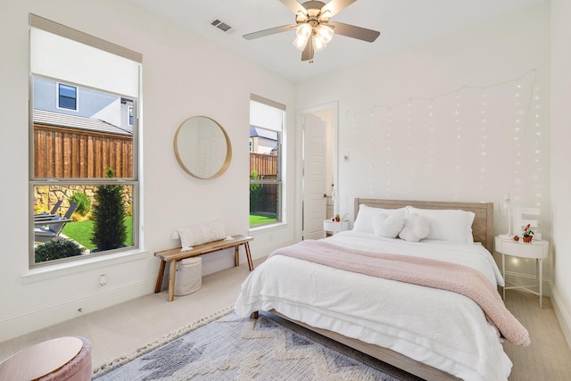 bedroom featuring a ceiling fan, visible vents, carpet, and baseboards