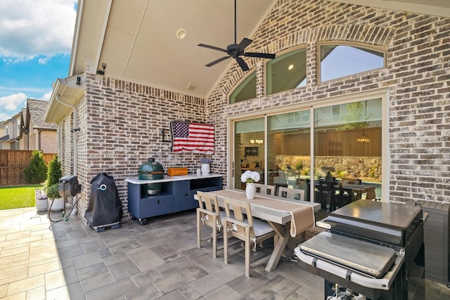 view of patio with a ceiling fan, outdoor dining space, grilling area, and fence