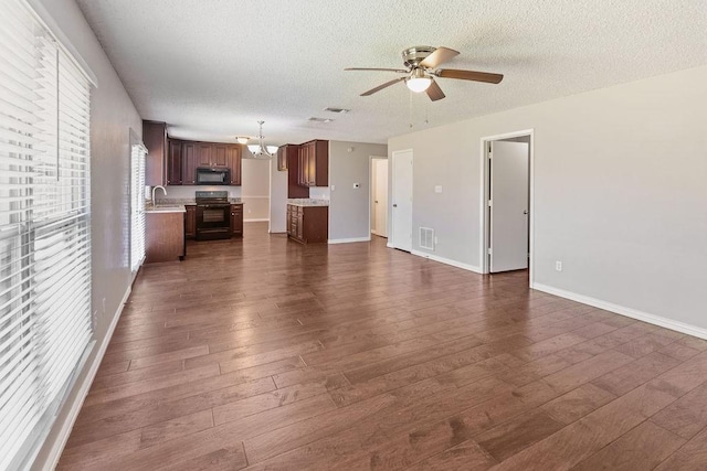 4109 Orchard Hill Dr, Arlington, TX 76016 - unfurnished living room featuring ceiling fan with notable chandelier, a sink, visible vents, a textured ceiling, and dark wood-type flooring