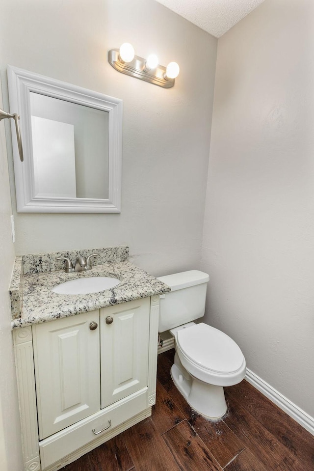 4109 Orchard Hill Dr, Arlington, TX 76016 - half bathroom featuring toilet, wood finished floors, vanity, and baseboards