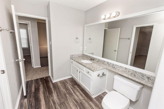 4109 Orchard Hill Dr, Arlington, TX 76016 - bathroom featuring wood finished floors, toilet, vanity, and baseboards