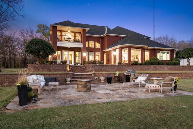 rear view of property with a balcony, a patio, roof with shingles, stucco siding, and french doors