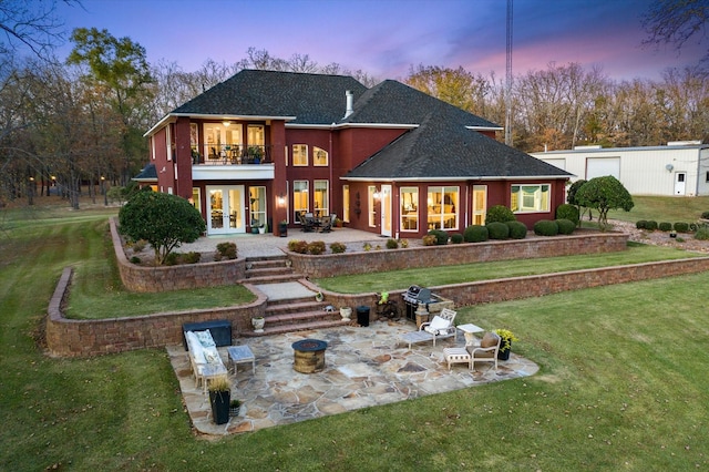 rear view of house featuring a balcony, a patio area, a yard, roof with shingles, and french doors