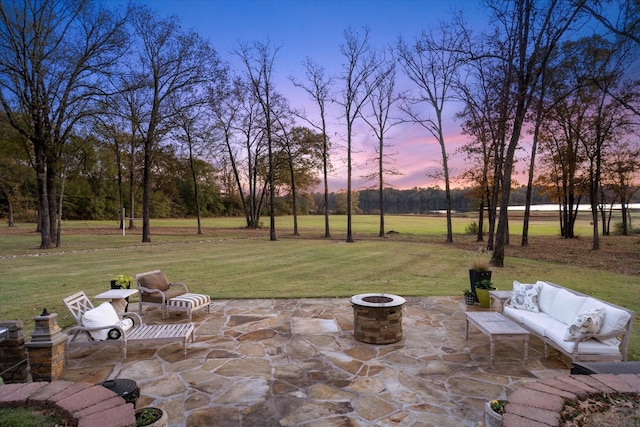 patio terrace at dusk with an outdoor living space with a fire pit and a yard