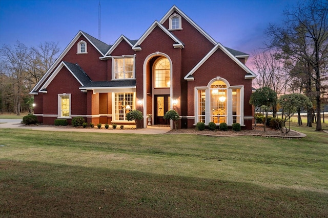 traditional-style home with a front yard and brick siding