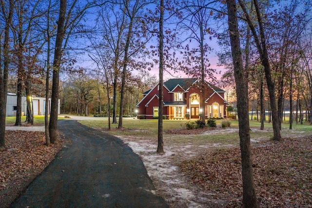 traditional-style house featuring a yard and aphalt driveway