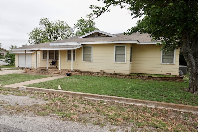 single story home with concrete driveway, roof with shingles, covered porch, an attached garage, and a front lawn