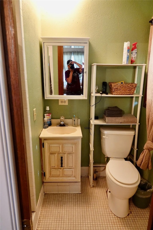 bathroom with vanity, toilet, tile patterned flooring, and baseboards
