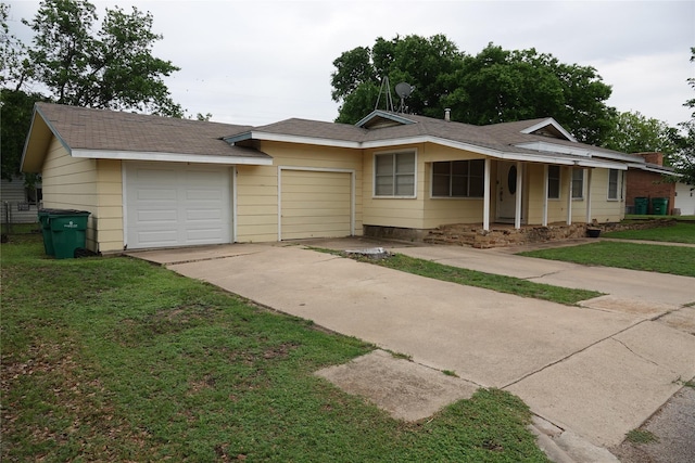 ranch-style house featuring concrete driveway, a front yard, a shingled roof, and an attached garage
