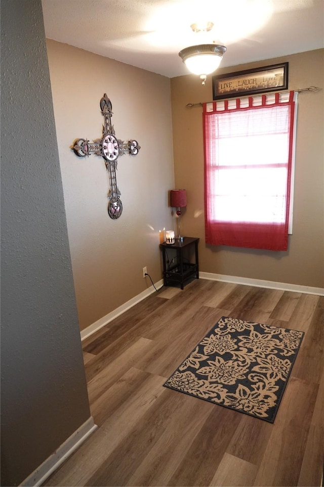 doorway to outside featuring wood finished floors and baseboards