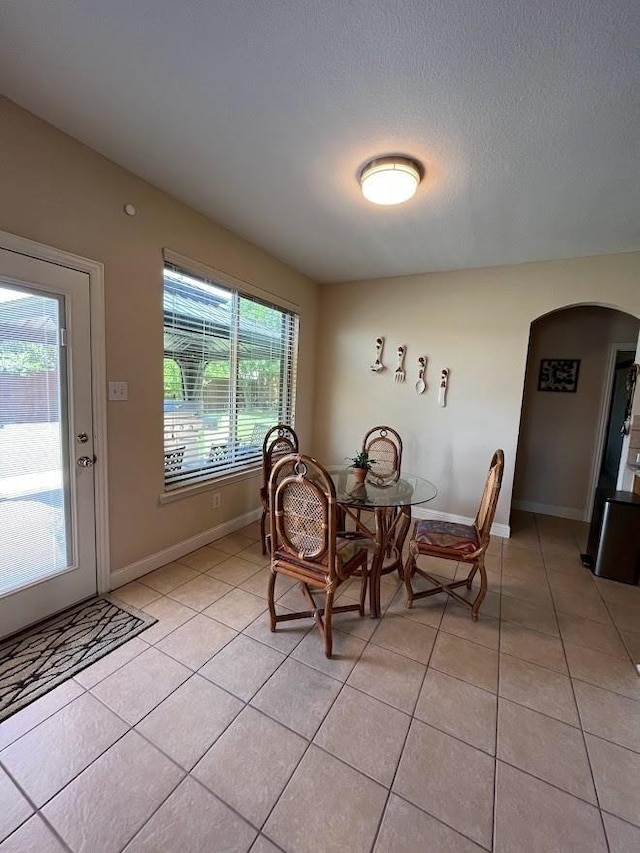 104 Misty Glen Ln, Murphy, TX 75094 - dining area with baseboards, arched walkways, and light tile patterned flooring