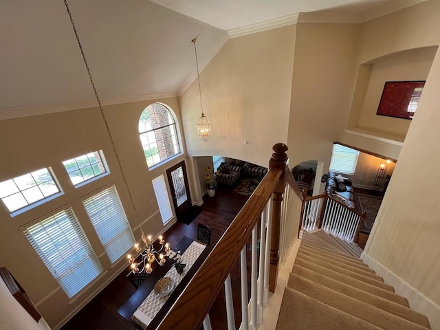 104 Misty Glen Ln, Murphy, TX 75094 - staircase with a notable chandelier, ornamental molding, high vaulted ceiling, and baseboards