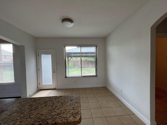 104 Misty Glen Ln, Murphy, TX 75094 - interior space featuring baseboards, light tile patterned floors, and arched walkways