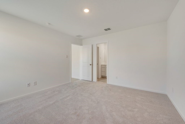 empty room with recessed lighting, visible vents, light colored carpet, and baseboards