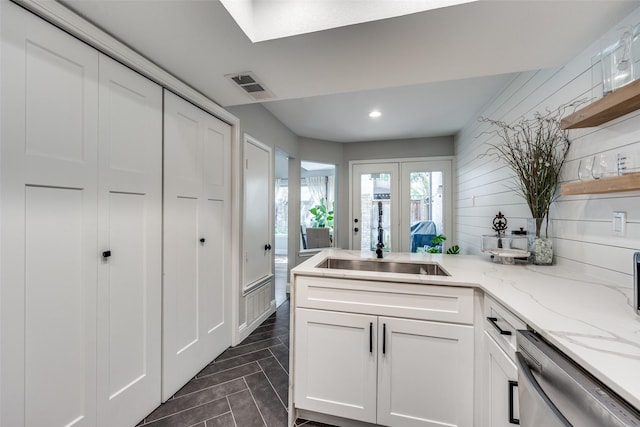kitchen with open shelves, visible vents, a peninsula, white cabinetry, and stainless steel dishwasher