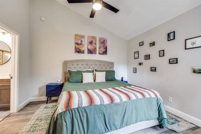 bedroom with lofted ceiling, ceiling fan, ensuite bathroom, baseboards, and wood finished floors