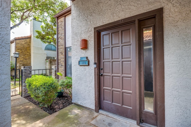 doorway to property featuring stucco siding