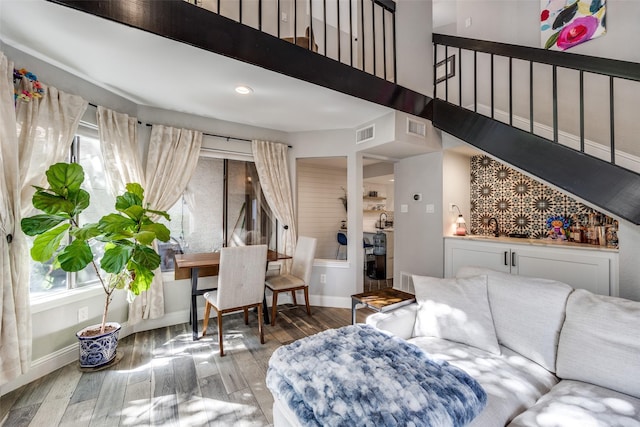 living area featuring visible vents, wood finished floors, and a healthy amount of sunlight