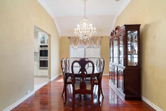 dining room with ornamental molding, a notable chandelier, wood finished floors, and baseboards