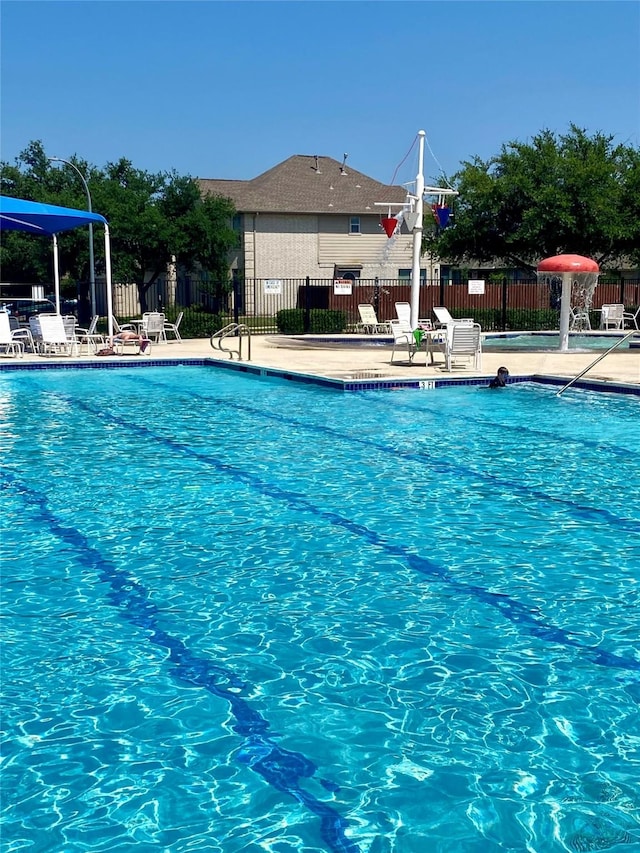 pool with a patio and fence