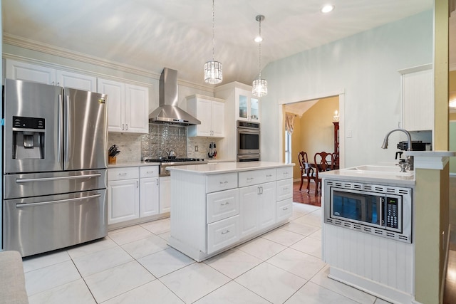 kitchen featuring wall chimney range hood, decorative backsplash, a sink, stainless steel appliances, and light countertops