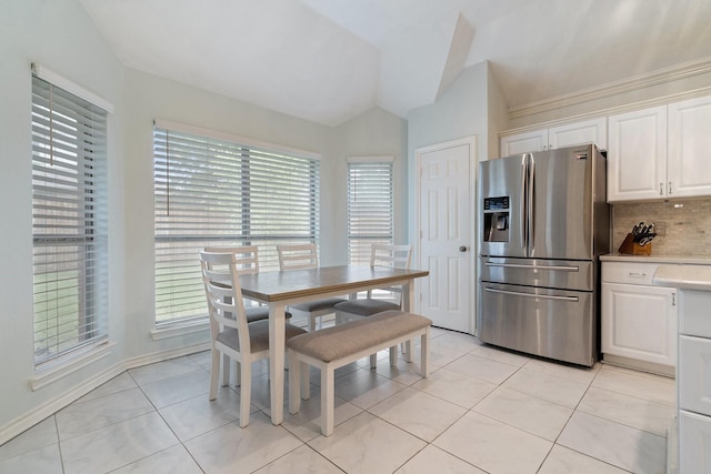 dining area featuring light tile patterned floors, lofted ceiling, and a healthy amount of sunlight