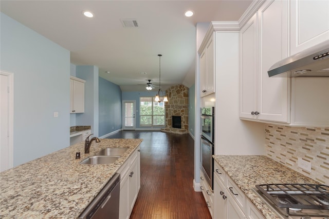 3017 Bella Lago Dr, Denton, TX 76210 - kitchen featuring a ceiling fan, a fireplace, dark wood-style floors, a sink, and stainless steel appliances
