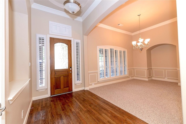 entryway featuring crown molding, a notable chandelier, and a wealth of natural light