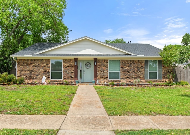 ranch-style house featuring brick siding, fence, roof with shingles, and a front lawn