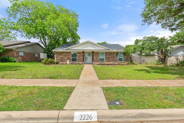 view of front of property featuring brick siding and a front lawn