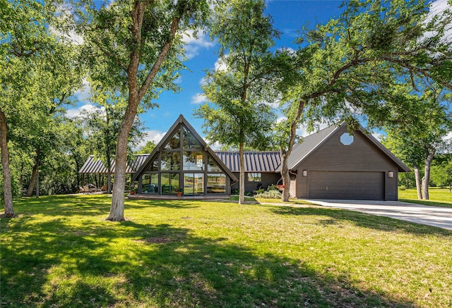 view of front facade featuring concrete driveway, a standing seam roof, metal roof, a front yard, and a garage