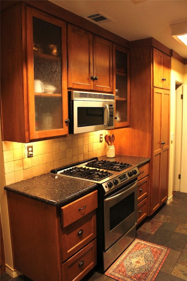 423 S O Connor Rd, Irving, TX 75060 - kitchen with glass insert cabinets, appliances with stainless steel finishes, backsplash, and visible vents