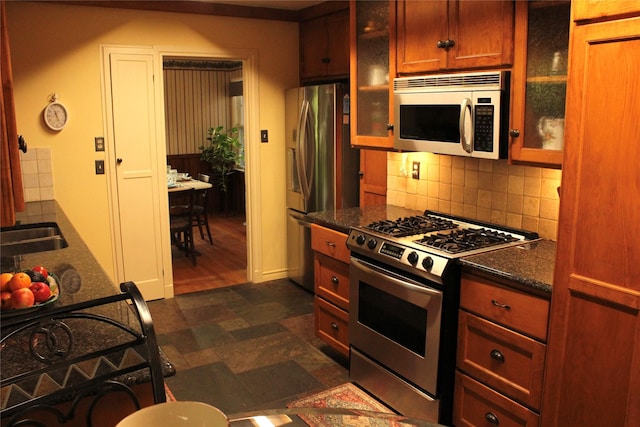 423 S O Connor Rd, Irving, TX 75060 - kitchen featuring glass insert cabinets, decorative backsplash, stainless steel appliances, and stone finish flooring