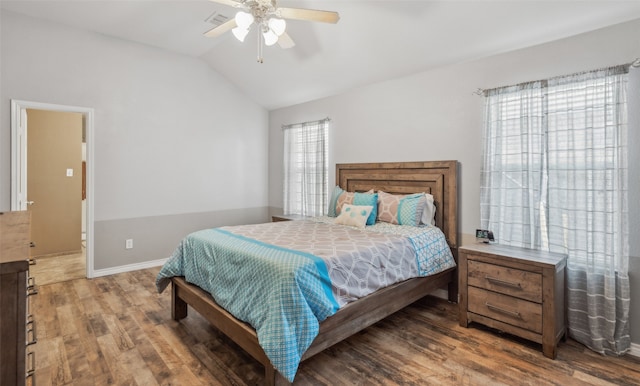 bedroom with baseboards, a ceiling fan, lofted ceiling, and wood finished floors