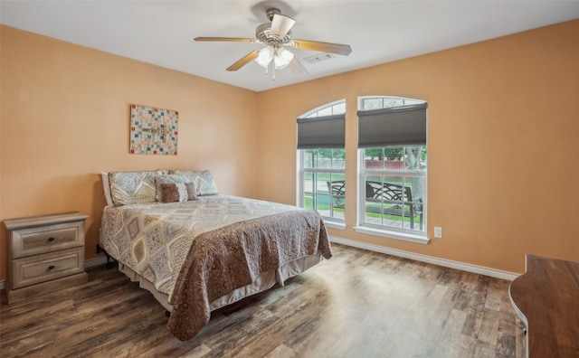 bedroom featuring baseboards, ceiling fan, wood finished floors, and visible vents