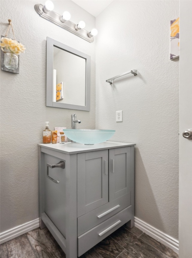 bathroom featuring vanity, baseboards, and wood finished floors