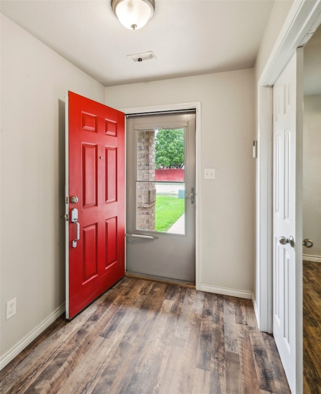 entrance foyer with baseboards, wood finished floors, and visible vents