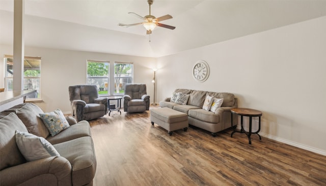 living room featuring baseboards, ceiling fan, and dark wood-style flooring