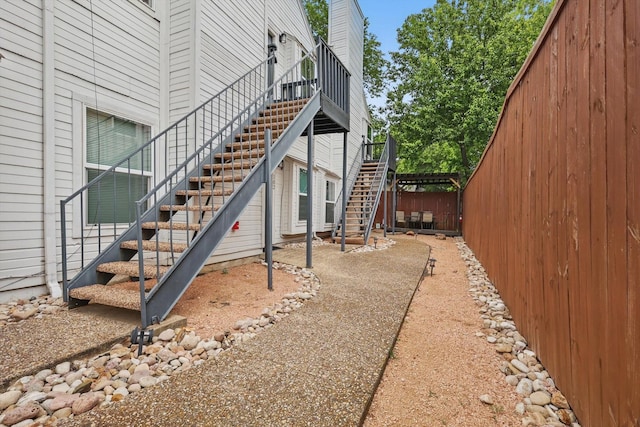 view of property exterior featuring stairway and fence