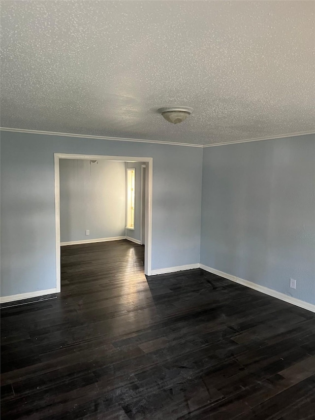 empty room with crown molding, a textured ceiling, baseboards, and dark wood-type flooring