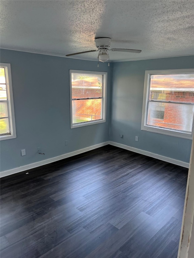 spare room featuring a textured ceiling, ceiling fan, dark wood-style flooring, and baseboards