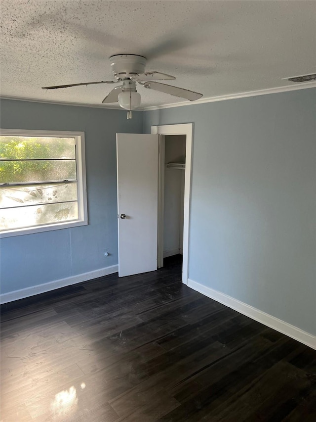 unfurnished bedroom featuring baseboards, ceiling fan, a textured ceiling, and dark wood-type flooring