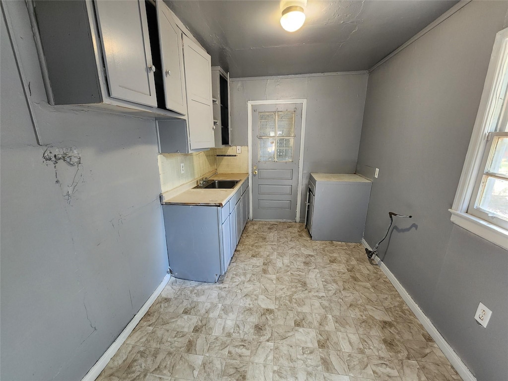 laundry area with baseboards and a sink
