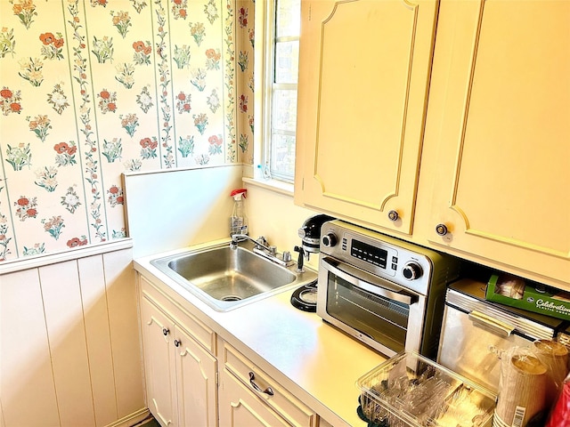 6114 Verona Ln, Shreveport, LA 71105 - kitchen featuring wallpapered walls, wainscoting, and light countertops