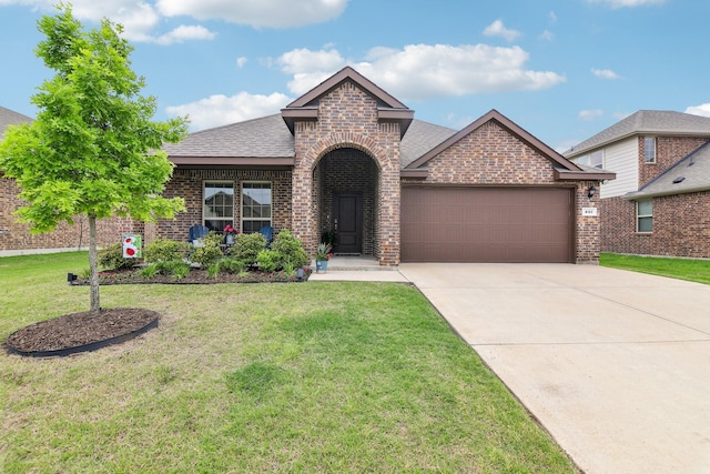 view of front facade featuring a shingled roof, an attached garage, brick siding, a front yard, and driveway