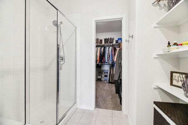 247 Carolina Trce, Fate, TX 75189 - bathroom with a shower stall, a walk in closet, tile patterned flooring, and baseboards