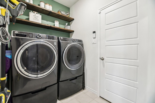 laundry room with light tile patterned floors, laundry area, and washer and clothes dryer